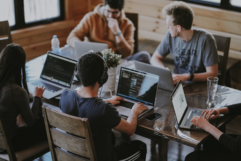 Team working at a table with laptops